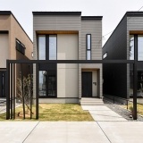 小幅の板を重ね張りしたような外壁をベースに柔らかなグレイッシュの吹付とシャープなハイサッシが映える上質なモダンデザイン住宅。