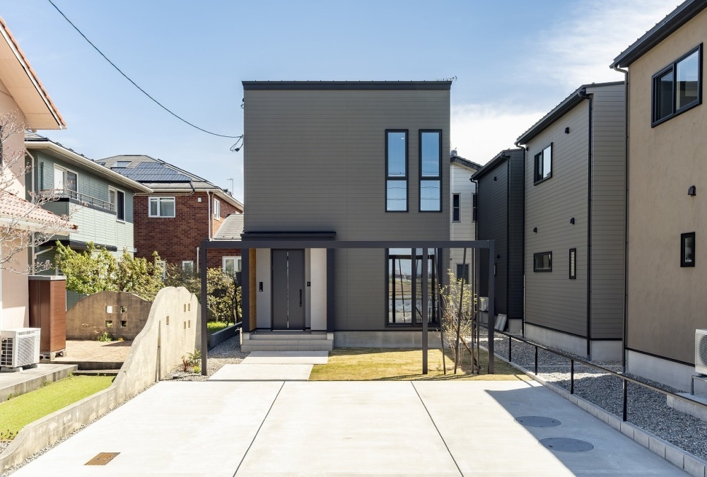 小幅の板を重ね張りしたような外壁をベースに天然木と吹付材の素材が調和するナチュラルモダンのデザイン住宅です。