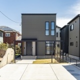 小幅の板を重ね張りしたような外壁をベースに天然木と吹付材の素材が調和するナチュラルモダンのデザイン住宅です。