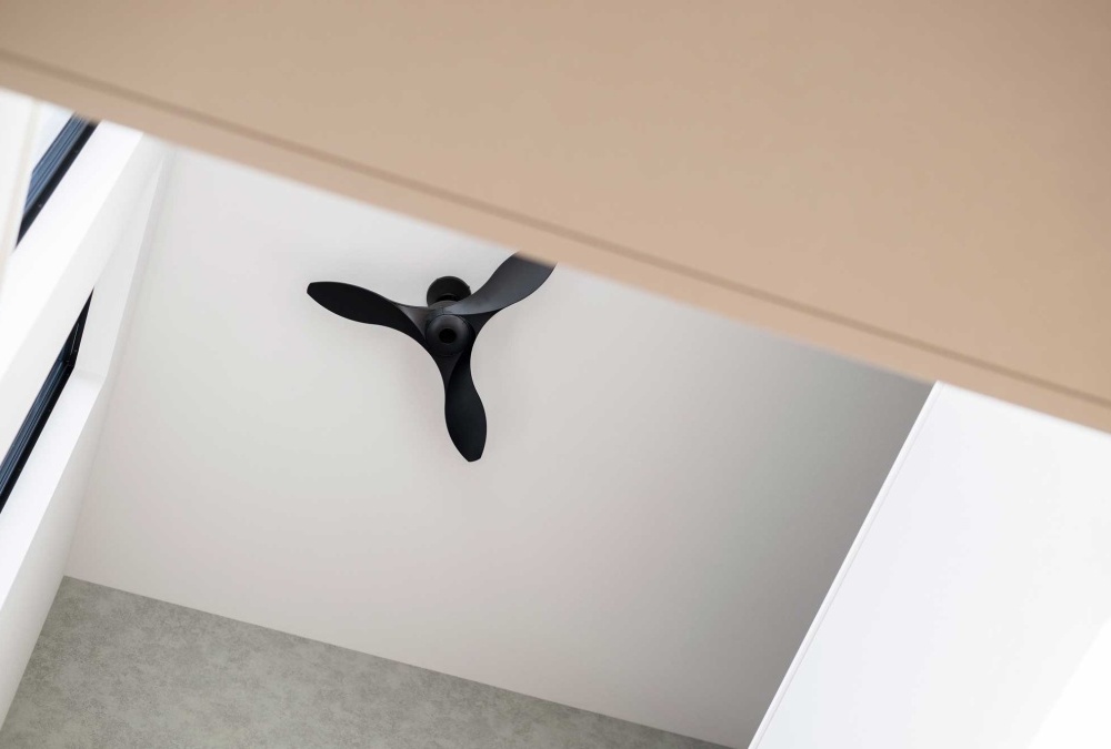 吹抜け天井にはシーリングファンを設置。空気循環と空間の広がりを促進します。